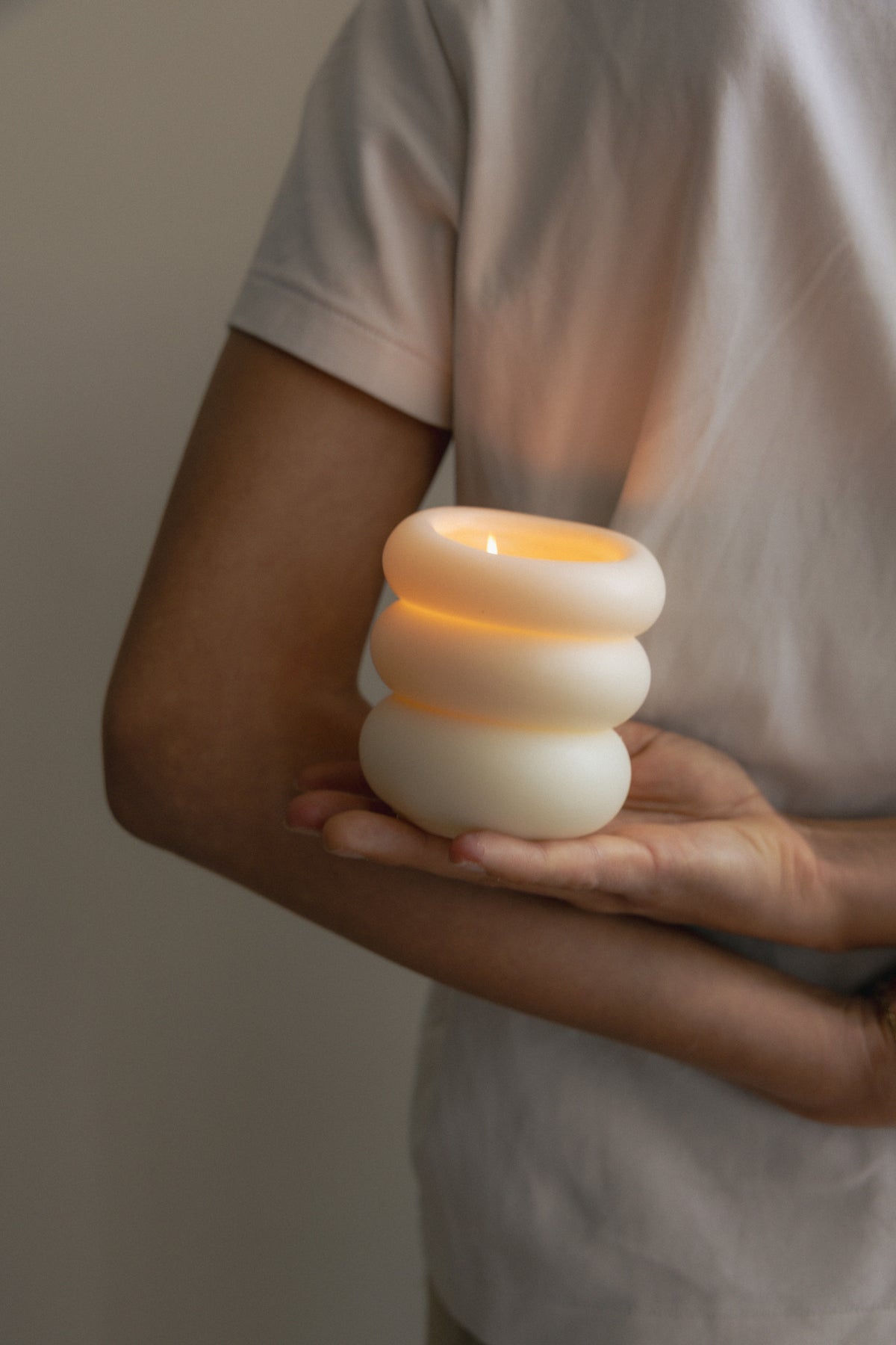 Pillar Candle I lit and held in one hand, the flame glowing through the wax