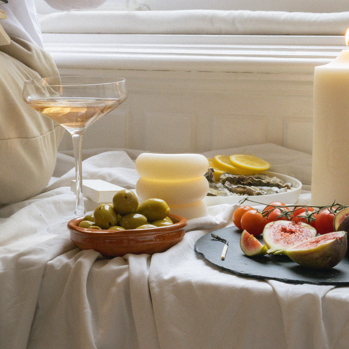 Pillar Candle I on a summer table with wine, olives and figs