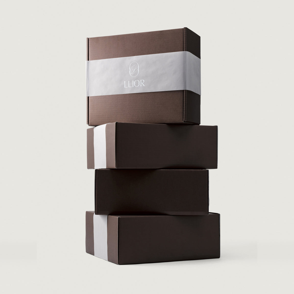 LLIOR gift boxes stacked, brown board with a paper band and the monogram